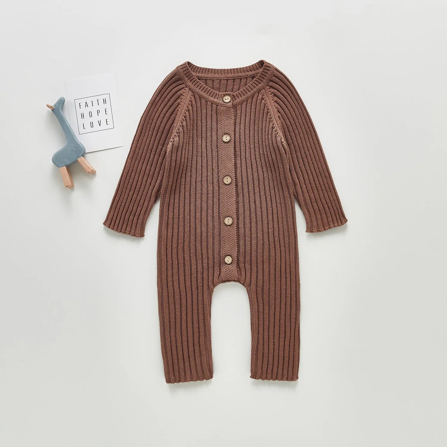Baby long-sleeved knitted jumpsuit romper pullover in beige, size 80cm, lying flat on a white background