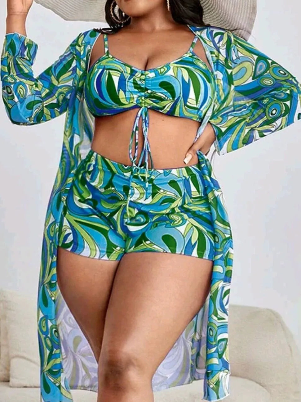 Women's floral print three-piece bikini set with cardigan on a mannequin.