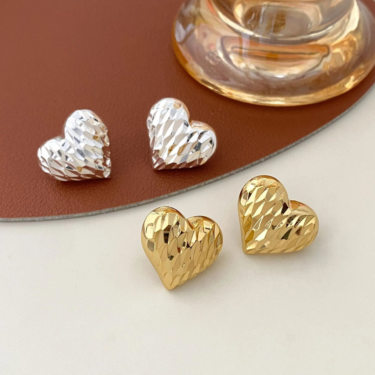 Heart-shaped copper earrings with electroplating, shown as gold or silver ear clips or studs, one pair.