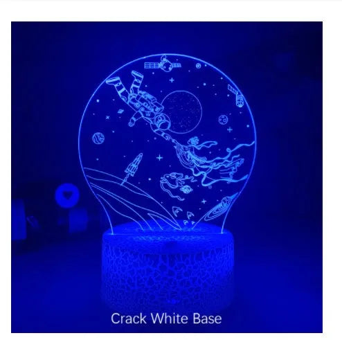 Colourful 3D night light in black base with remote control showing green glow on dark surface