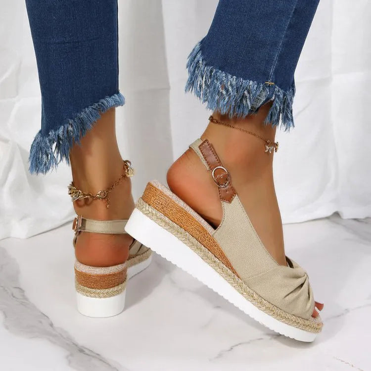 Peep toe platform sandal with one-line buckle strap, cloth upper, rubber sole, shown in black.