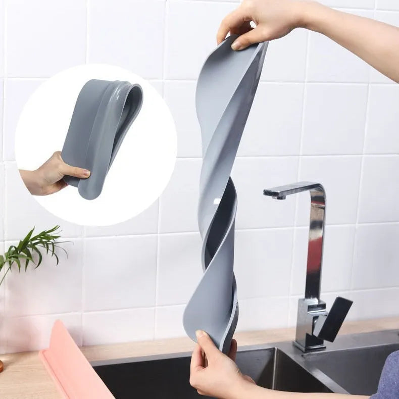 Grey blue silicone sink water blocking plate measuring 52mm by 85mm on a kitchen counter.