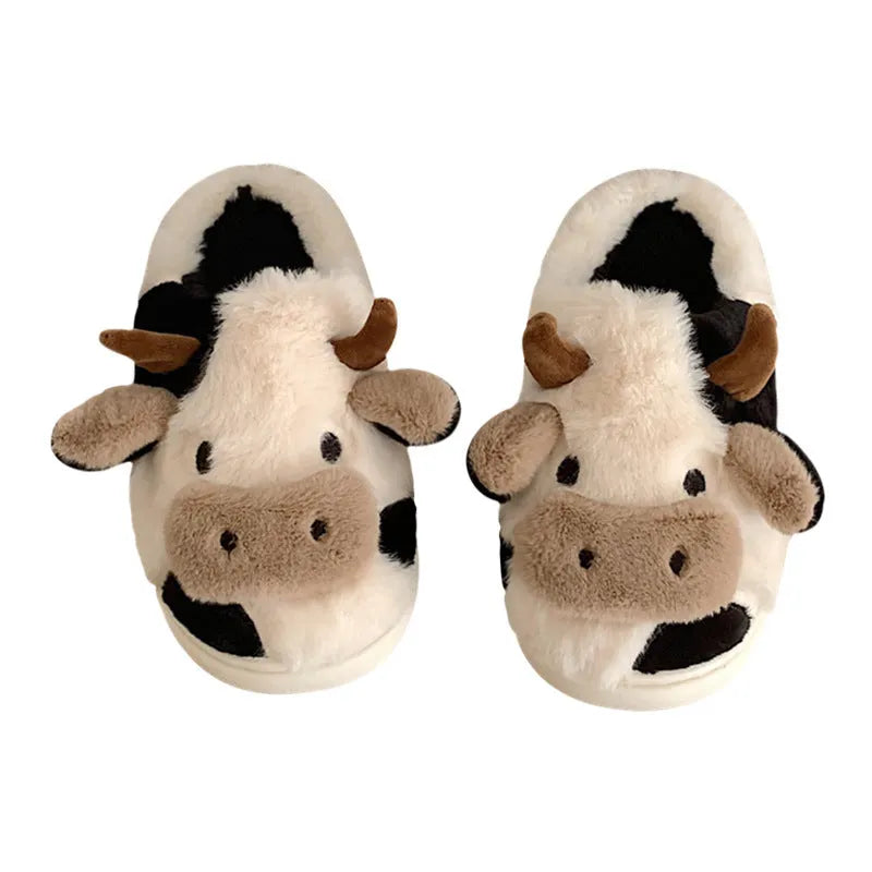 White women's cow pattern slippers made of soft faux fur with textured anti-slip soles.