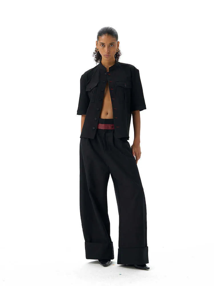 Black handmade loose-fit half sleeve hunting shirt with a shirt collar on a hanger.