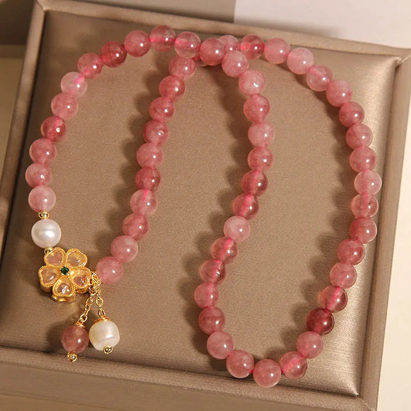 Double ring women's bracelet with strawberry quartz four-leaf clover charms and alloy gemstone details.