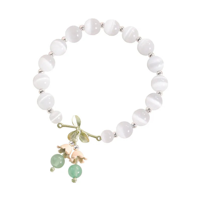 Close-up of a women's opal beaded bracelet with diamond-shaped cat's eye stones on a wrist.