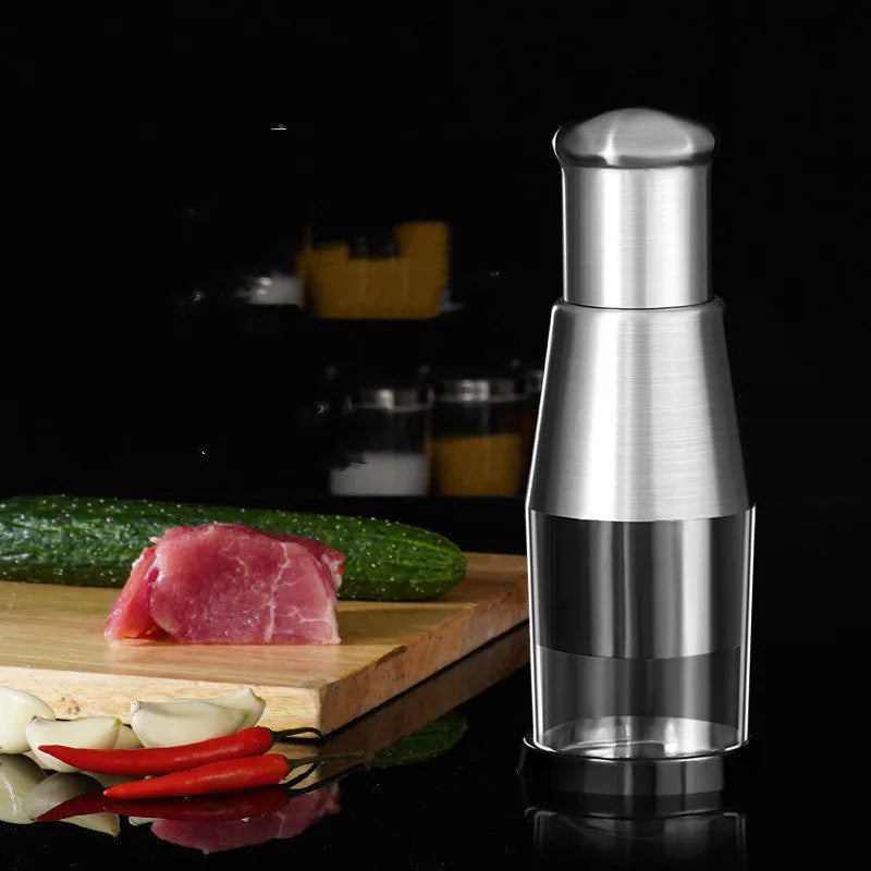 Manual garlic press and onion chopper with stainless steel blades on a kitchen counter.